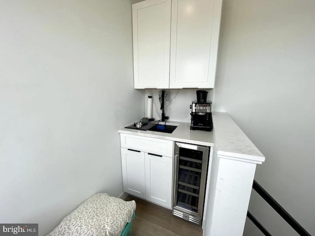 bar with white cabinetry, beverage cooler, and dark wood-type flooring