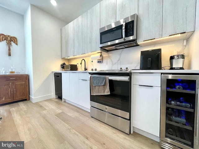 kitchen featuring light hardwood / wood-style floors, wine cooler, and stainless steel appliances