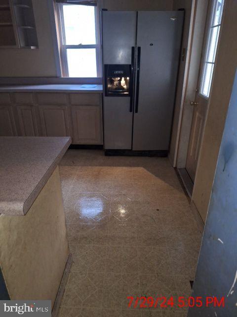 kitchen featuring stainless steel fridge with ice dispenser and light tile patterned floors