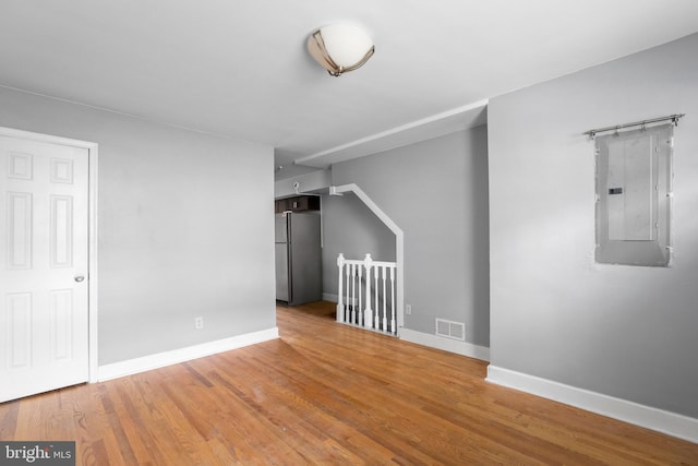 unfurnished room featuring hardwood / wood-style floors and electric panel