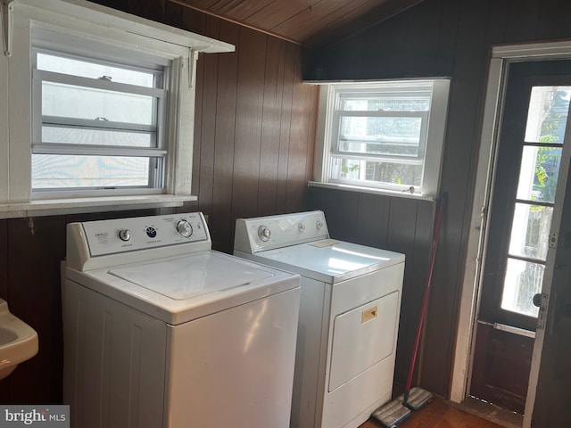 washroom with independent washer and dryer, plenty of natural light, and wooden walls