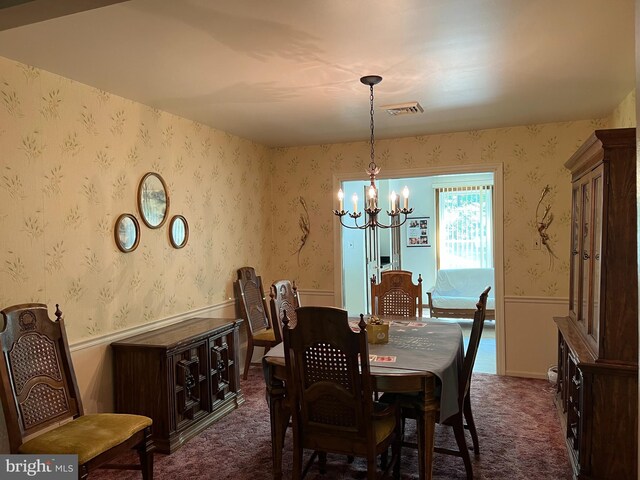 dining room featuring a notable chandelier and dark colored carpet