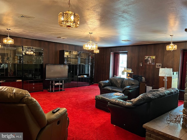 carpeted living room featuring a textured ceiling and wooden walls