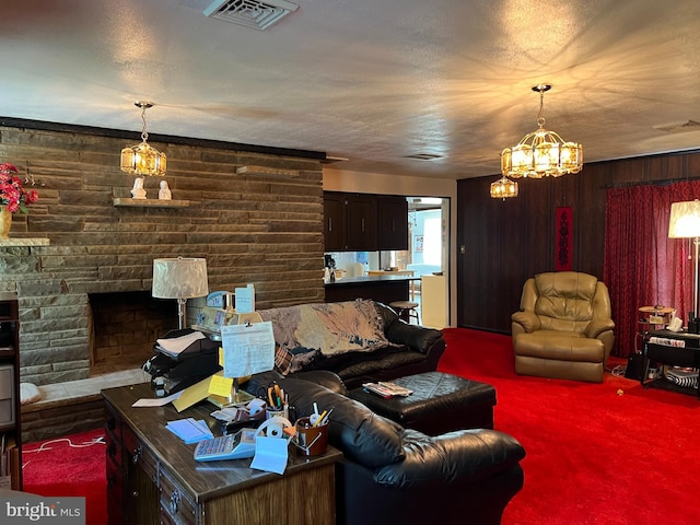 carpeted living room featuring a fireplace, wooden walls, and a notable chandelier