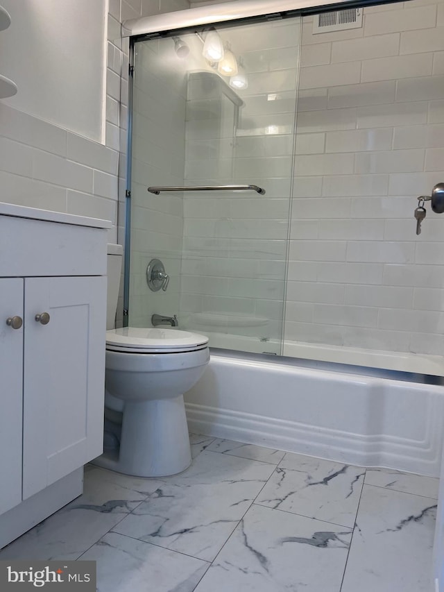 full bathroom with shower / bath combination with glass door, vanity, tile patterned flooring, and toilet