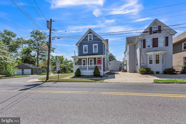 view of front of house featuring covered porch, an outbuilding, and a garage