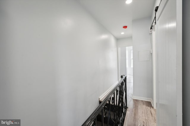 hall featuring light hardwood / wood-style floors and a barn door