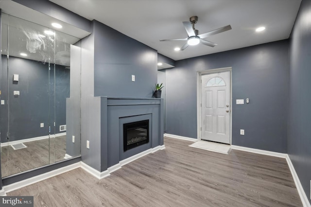 unfurnished living room with ceiling fan and hardwood / wood-style flooring