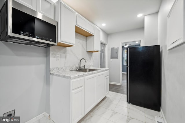 kitchen with light wood-type flooring, sink, tasteful backsplash, and white cabinetry