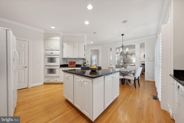 kitchen featuring an inviting chandelier, white appliances, white cabinetry, and light hardwood / wood-style floors