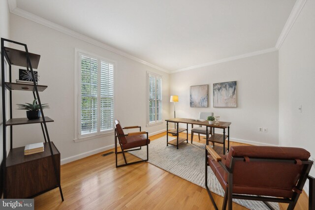 home office featuring plenty of natural light, ornamental molding, and light hardwood / wood-style floors