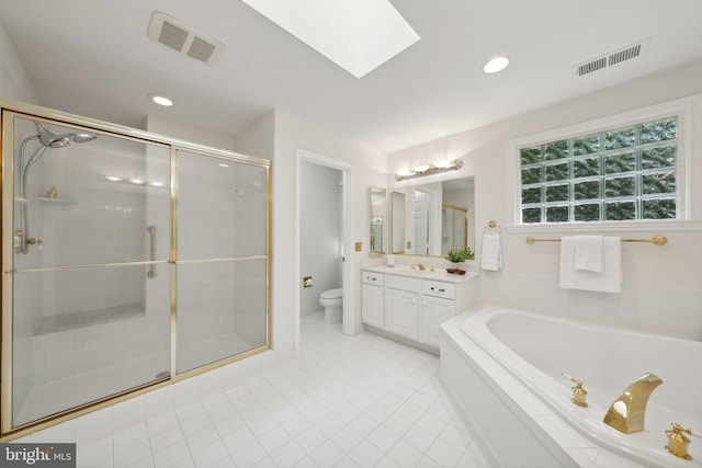 full bathroom with a skylight, independent shower and bath, toilet, and vanity