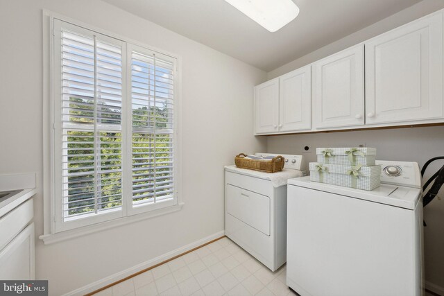 laundry room featuring separate washer and dryer and cabinets