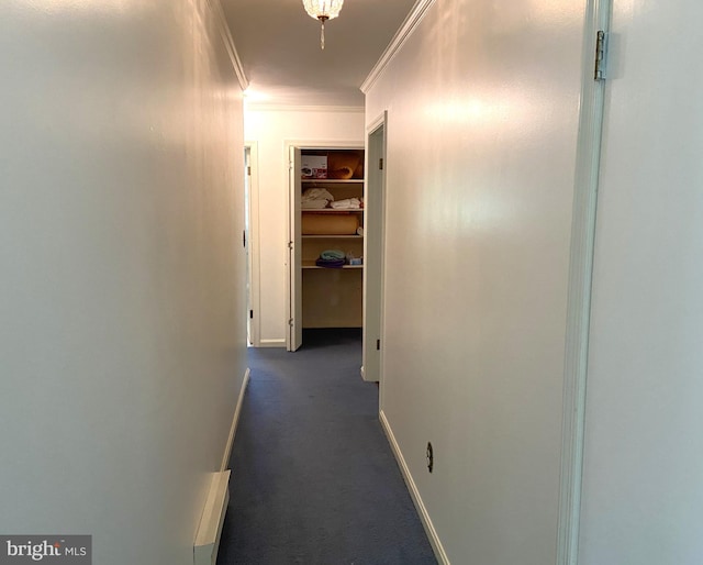 corridor featuring crown molding and dark colored carpet