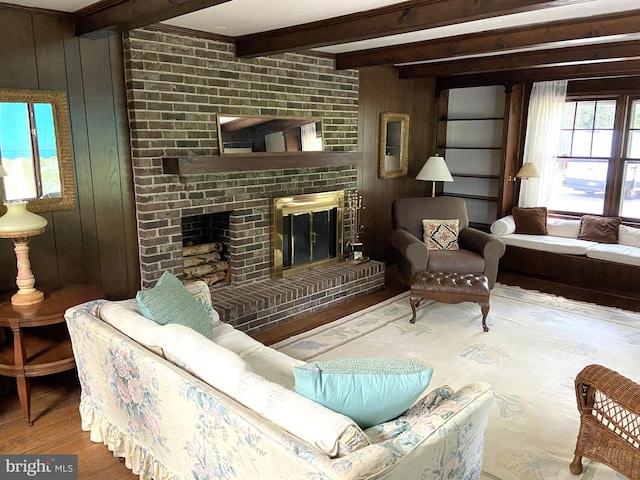 living room featuring a brick fireplace, wooden walls, beam ceiling, and light hardwood / wood-style floors