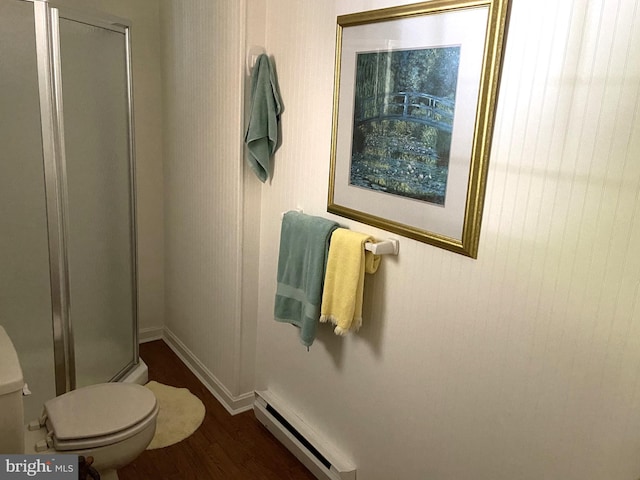 bathroom featuring baseboard heating, wood-type flooring, toilet, and a shower with shower door