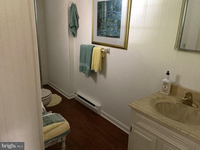 bathroom featuring a baseboard radiator, toilet, vanity, and hardwood / wood-style floors