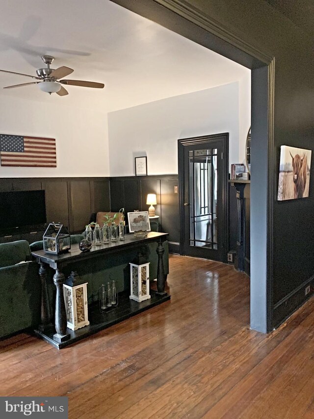 living room with ceiling fan and dark wood-type flooring