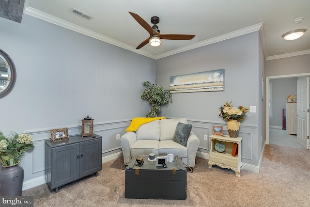 living area featuring crown molding, light carpet, and ceiling fan