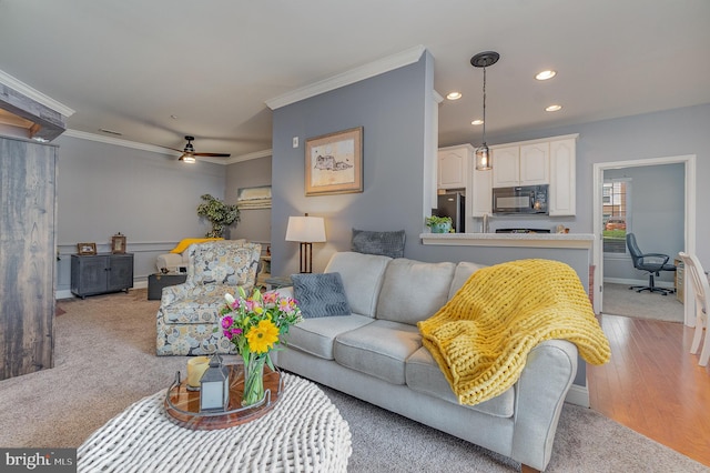 living room featuring ornamental molding, light hardwood / wood-style floors, and ceiling fan