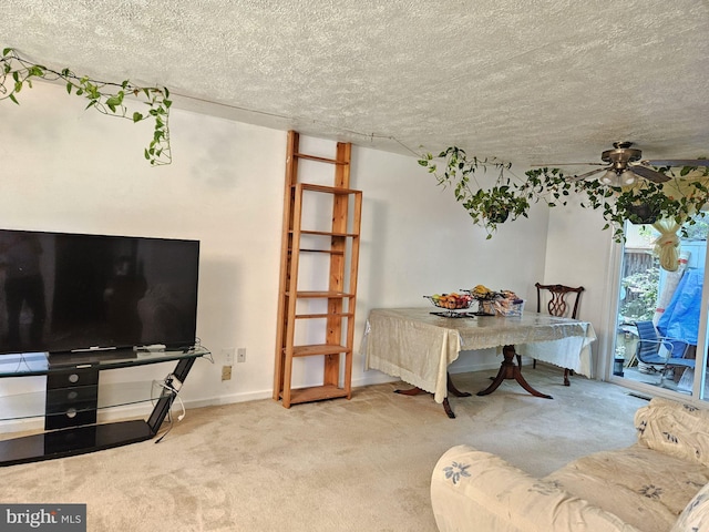 dining room featuring ceiling fan, a textured ceiling, and light carpet