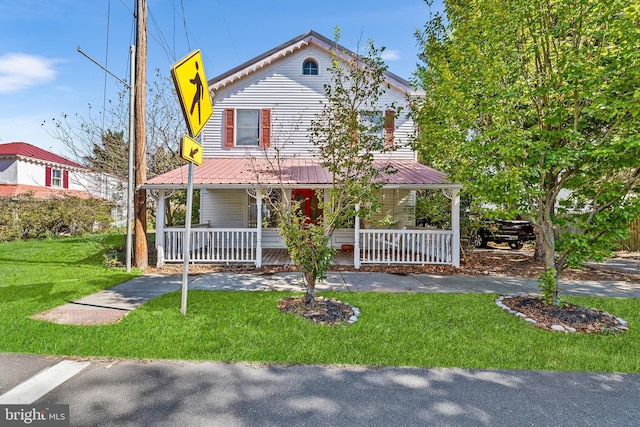 farmhouse-style home featuring a porch and a front yard