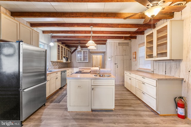 kitchen with pendant lighting, sink, hardwood / wood-style floors, and appliances with stainless steel finishes