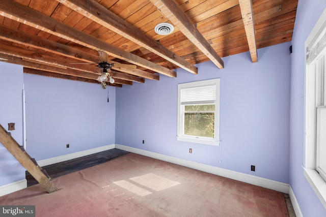 carpeted empty room featuring wood ceiling, ceiling fan, and beamed ceiling