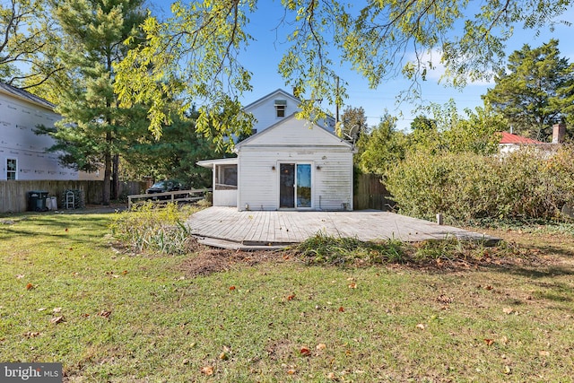 rear view of property with a patio, a sunroom, a yard, and a wooden deck