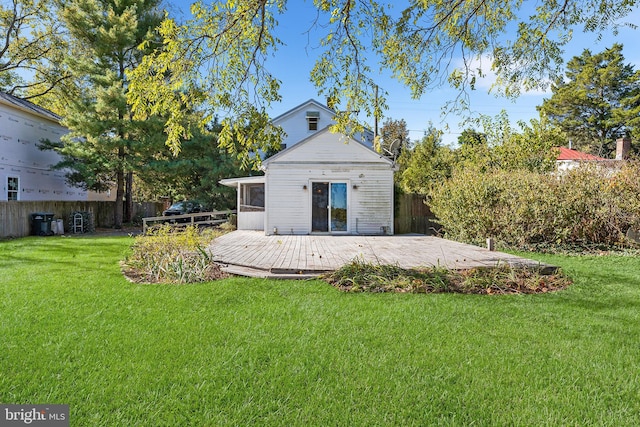 back of house with a wooden deck and a lawn