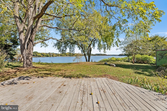 wooden terrace featuring a water view and a yard