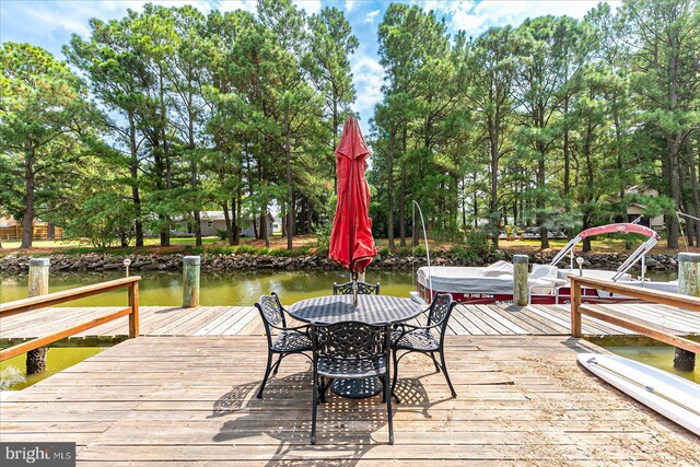 dock area with a water view and a lawn