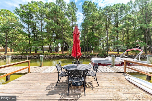 wooden deck with a dock and a water view