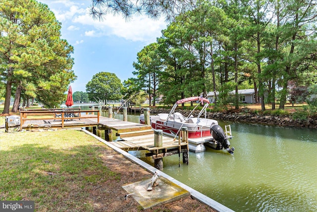 dock area with a water view and a yard