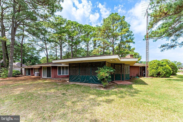 rear view of house with a lawn and a sunroom