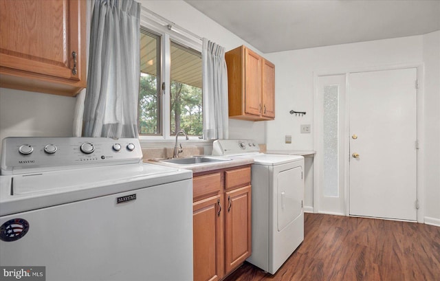 clothes washing area featuring dark wood-style floors, washing machine and dryer, cabinet space, and a sink