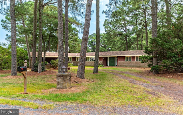 ranch-style home with a front yard, brick siding, and driveway