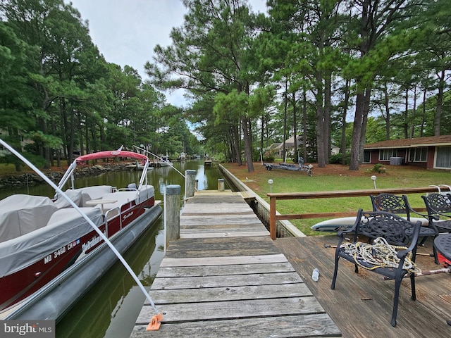 dock area with a water view and a lawn