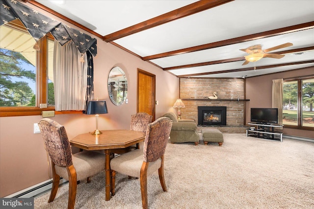 dining space featuring a fireplace, a baseboard radiator, carpet flooring, ceiling fan, and beamed ceiling