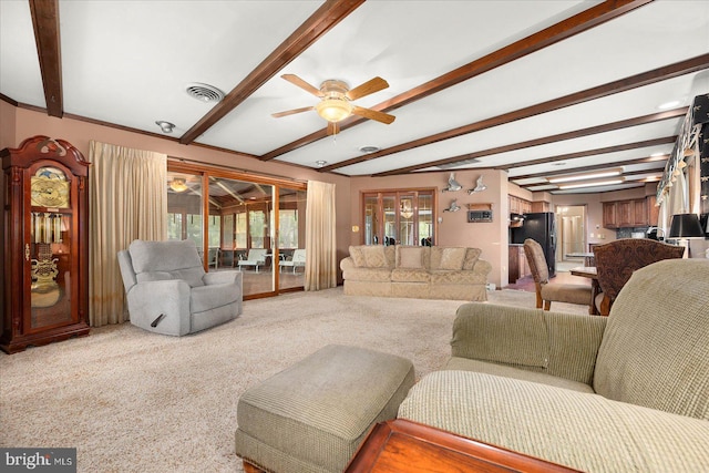 carpeted living room featuring a ceiling fan, visible vents, and beamed ceiling