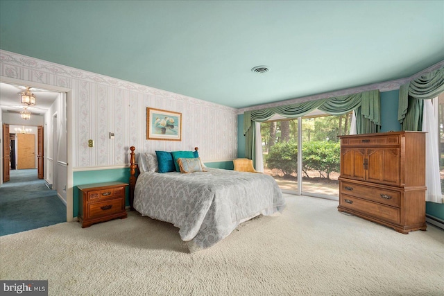 carpeted bedroom featuring wallpapered walls, visible vents, and access to exterior