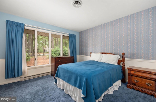 carpeted bedroom with a baseboard heating unit, a wainscoted wall, visible vents, and wallpapered walls