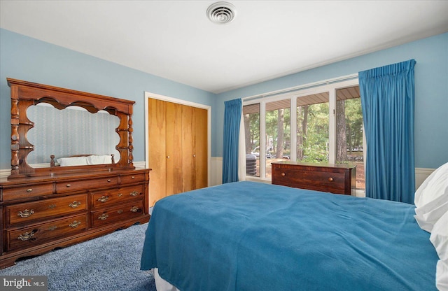 bedroom featuring visible vents, a closet, and wainscoting