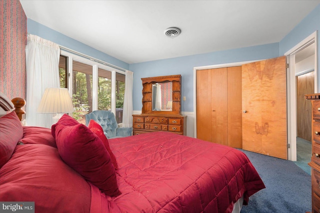 carpeted bedroom featuring visible vents and a closet