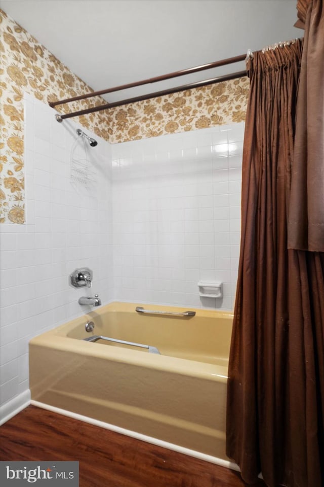 bathroom with shower / bath combo, tile walls, and wallpapered walls