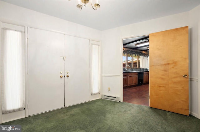 entrance foyer with baseboard heating and dark colored carpet