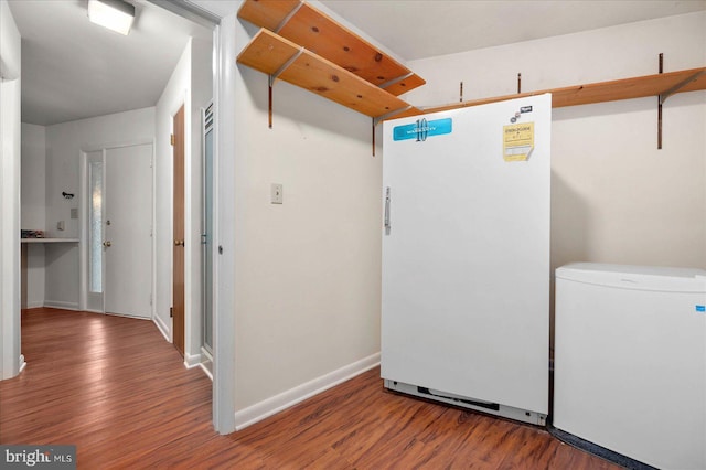 washroom with wood finished floors and baseboards