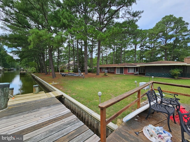 dock area with a water view and a yard