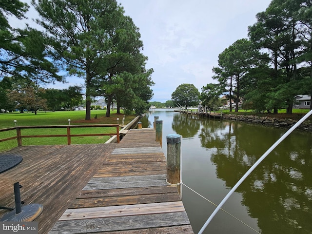 dock area with a yard and a water view