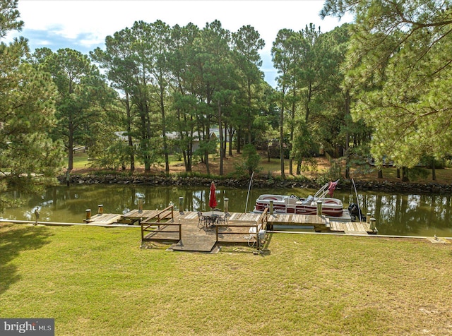 view of dock with a water view and a lawn